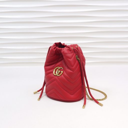 GUCCI GG Marmont Mini Bucket Bag. Original Quality Bag including gift box, literature, dust bag, authenticity card. The world of GG Marmont expands with the introduction of a mini bucket bag shape crafted from Matelassé leather in vibrant tones. Inspired by an archival design from the '70s, a hallmark era of the House, the Double G decorates the front of this accessory. Featuring a chain strap and drawstring closure the versatile shape can be worn as shoulder and as a crossbody bag.