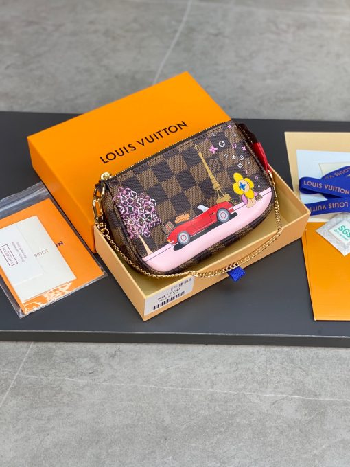 LOUIS VUITTON Mini Pochette Accessoires Pouch. High-End Quality Bag including gift box, care book, dust bag, authenticity card. This pochette is crafted of traditional damier checkered toile canvas in brown. The bag features a colorful depiction of house mascot Vivienne driving by the Eiffel Tower in Paris, and a polished brass chain link wristlet strap. The top zipper opens to a compact fabric interior. This is a chic and playful pochette, with luxury and style.