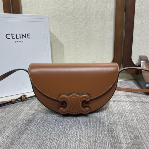 CELINE Besace Cuir Triomphe. High-End Quality Bag including gift box, care book, dust bag, authenticity card. Offered in the half-moon shape that’s all the rage now, the significantly wider format measures 23 cm from tip to tip. Each bag opens via a snap button closure to reveal a roomy interior compartment and a flat inner pocket. Another noticeable feature of the bag lies in the oversized Triomphe logo. With tonal stitching along the edges, the logo on the Triomphe Canvas comes in contrasting Tan leather. For a monochrome effect, go for the Ice Blue and Tan with logos in matching colours.