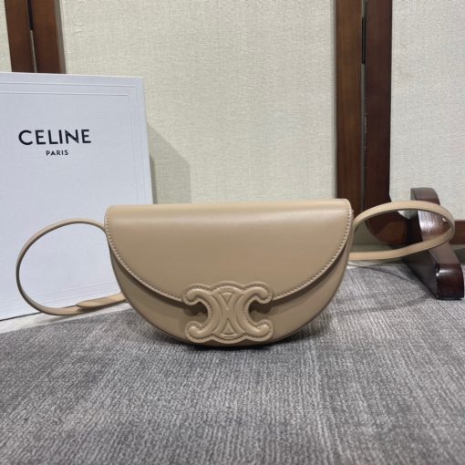 CELINE Besace Cuir Triomphe. High-End Quality Bag including gift box, care book, dust bag, authenticity card. Offered in the half-moon shape that’s all the rage now, the significantly wider format measures 23 cm from tip to tip. Each bag opens via a snap button closure to reveal a roomy interior compartment and a flat inner pocket. Another noticeable feature of the bag lies in the oversized Triomphe logo. With tonal stitching along the edges, the logo on the Triomphe Canvas comes in contrasting Tan leather. For a monochrome effect, go for the Ice Blue and Tan with logos in matching colours.