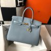 HERMÈS Birkin. Exquisite Craftsmanship and Timeless Elegance: Discover the Allure of the HERMES Birkin Bag Large Leather Top Handle. Designed with the actress Jane Birkin in mind, the Birkin bag is a contemporary development of the Kelly bag. Created based on Jane's suggestions, it was architected to be more significant to fit modern women's fast-paced life, with several minor yet outstanding adaptations, such as the elongated top handles. The French Birkin 30 bag is a classic touch of elegance to your look! The accessory features a trapeze body, a pebbled leather texture, a hanging key fob, gold-tone hardware, round top handles, a padlock fastening detail, a foldover top with twist-lock closure, a front center logo stamp, an internal zipped pocket, and purse feet.