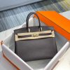 HERMÈS Birkin. Exquisite Craftsmanship and Timeless Elegance: Discover the Allure of the HERMES Birkin Bag Large Leather Top Handle. Designed with the actress Jane Birkin in mind, the Birkin bag is a contemporary development of the Kelly bag. Created based on Jane's suggestions, it was architected to be more significant to fit modern women's fast-paced life, with several minor yet outstanding adaptations, such as the elongated top handles. The French Birkin 30 bag is a classic touch of elegance to your look! The accessory features a trapeze body, a pebbled leather texture, a hanging key fob, gold-tone hardware, round top handles, a padlock fastening detail, a foldover top with twist-lock closure, a front center logo stamp, an internal zipped pocket, and purse feet.