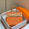 HERMÈS Birkin. Exquisite Craftsmanship and Timeless Elegance: Discover the Allure of the HERMES Birkin Bag Large Leather Top Handle. Designed with the actress Jane Birkin in mind, the Birkin bag is a contemporary development of the Kelly bag. Created based on Jane's suggestions, it was architected to be more significant to fit modern women's fast-paced life, with several minor yet outstanding adaptations, such as the elongated top handles. The French Birkin 30 bag is a classic touch of elegance to your look! The accessory features a trapeze body, a pebbled leather texture, a hanging key fob, gold-tone hardware, round top handles, a padlock fastening detail, a foldover top with twist-lock closure, a front center logo stamp, an internal zipped pocket, and purse feet.
