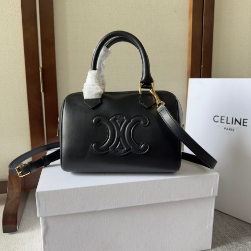 CELINE Small Boston Cuir Triomphe. Style meets sophistication with this timeless Celine Bag. The Celine Small Boston Cuir Triomphe is a classic accessory that is perfect for both day and night. It is made out of smooth calfskin leather with a stitched monogram pattern that creates an elegant, modern look. The bag features a removable and adjustable shoulder strap, a top handle for carrying, and a zipped closure. It also has a main spacious compartment, and one inner flat pocket. It has a small and compact size, perfect for days when you don't want to carry too much. The timeless design will never go out of style, and you'll be sure to feel confident and stylish with this bag on your arm.