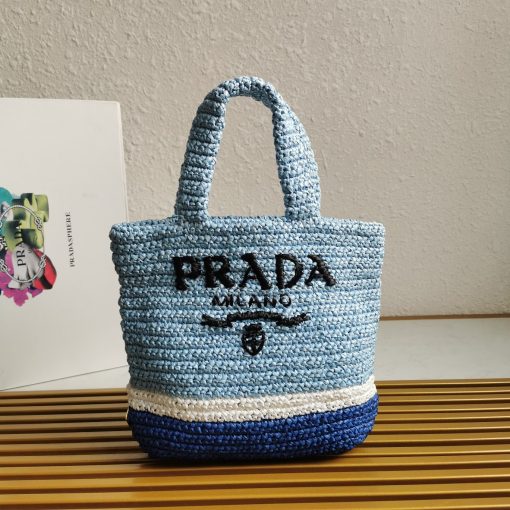 PRADA Small Crochet Tote Bag. Elevate Your Look with an Exquisite Tote Bag! This exquisite tote bag has a deconstructed design made of a light, natural material with a summery mood, raffia-effect yarn. Embroidered lettering logo decorates the front, and the emblematic triangle in enameled metal is the perfect finishing touch to the side.