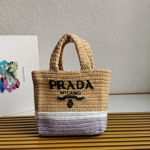 PRADA Small Crochet Tote Bag. Elevate Your Look with an Exquisite Tote Bag! This exquisite tote bag has a deconstructed design made of a light, natural material with a summery mood, raffia-effect yarn. Embroidered lettering logo decorates the front, and the emblematic triangle in enameled metal is the perfect finishing touch to the side.