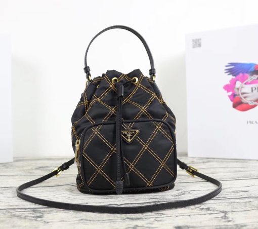 PRADA Quilted Bucket Bag. Original Quality Bag including gift box, care book, dust bag, authenticity card. PRADA nylon bucket bag with tessuto-impunturato quilted topstitching. Leather top handle. Drawstring top. Detachable Shoulder Strap. Front Zip Pocket with logo plate.