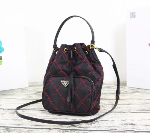 PRADA Quilted Bucket Bag. Original Quality Bag including gift box, care book, dust bag, authenticity card. PRADA nylon bucket bag with tessuto-impunturato quilted topstitching. Leather top handle. Drawstring top. Detachable Shoulder Strap. Front Zip Pocket with logo plate.