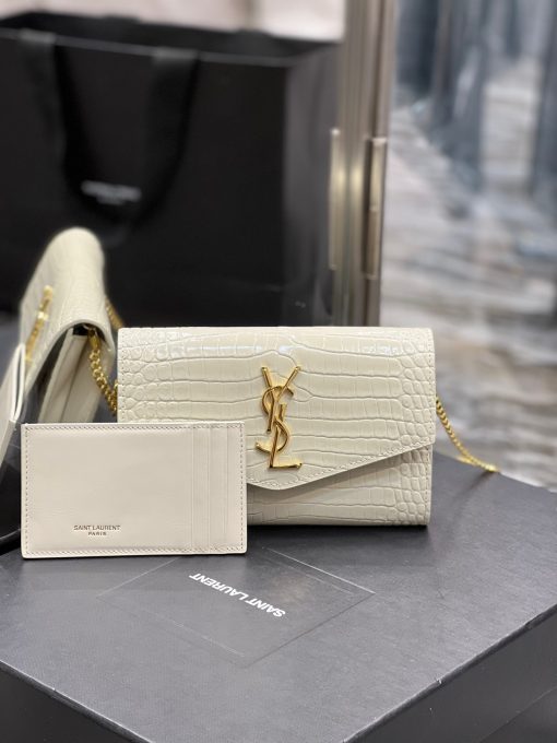 SAINT LAURENT Uptown Chain Wallet. High-End Quality Bag including gift box, care book, dust bag, authenticity card. Mini envelope bag decorated with the cassandre, featuring a removable chain strap for shoulder or hand carry as a clutch. A fragments card case with three card slots is included.