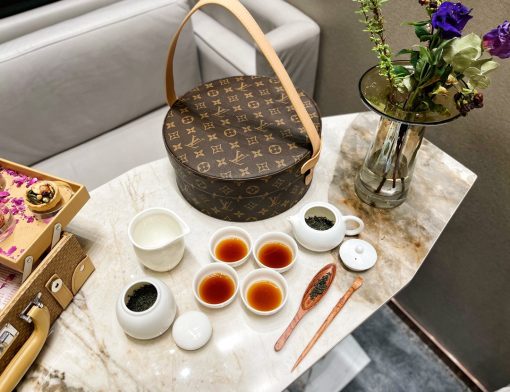 LOUIS VUITTON Boîte The Ronde. Original Quality Set including gift box, care book, dust bag, authenticity card. Inspired by the Hat Box, this modern and nomadic Round Tea Box contains degustation material for four guests.