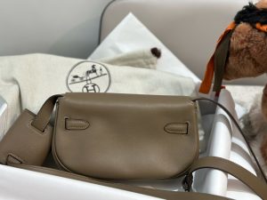 HERMÈS Swift Kelly Moove: Classic Elegance, Modern Flair. Discover the reimagined elegance of the Kelly Moove, where timeless style meets modern innovation. Building on the iconic silhouette of the beloved Kelly Banana bag, the Kelly Moove adds a fresh twist with an irresistibly chic detachable mini pouch on its strap. This miniature version of the Kelly is more than just a pretty accessory—it’s a practical companion perfect for holding essentials like AirPods or credit cards. Together, this mother-and-daughter duo brings both style and function to the forefront, making the Kelly Moove a must-have for those who appreciate classic design with a contemporary flair. Elevate your look with this sophisticated piece that seamlessly blends tradition with today’s needs.