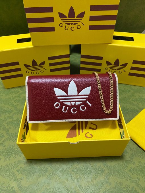 GUCCI X ADIDAS Wallet With Chain.  Original Quality Wallet including gift box, care book, dust bag, authenticity card. Part of the GUCCI X ADIDAS collection, this chain wallet features the Gucci Trefoil print. Emblematic House’s motifs mix with those of the historic sportswear brand adidas. The collection sees both heritages encoded in a trio of lines, where adidas and Gucci combine archival emblems. Creative Director, Alessandro Michele pulls inspiration from his memories of the ‘80s and ‘90s for a collection that is both nostalgia-driven and contemporary.