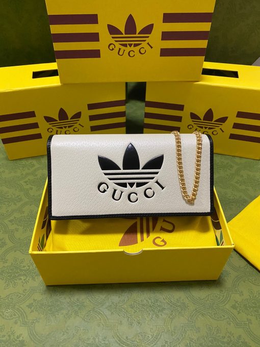 GUCCI X ADIDAS Wallet With Chain.  Original Quality Wallet including gift box, care book, dust bag, authenticity card. Part of the GUCCI X ADIDAS collection, this chain wallet features the Gucci Trefoil print. Emblematic House’s motifs mix with those of the historic sportswear brand adidas. The collection sees both heritages encoded in a trio of lines, where adidas and Gucci combine archival emblems. Creative Director, Alessandro Michele pulls inspiration from his memories of the ‘80s and ‘90s for a collection that is both nostalgia-driven and contemporary.