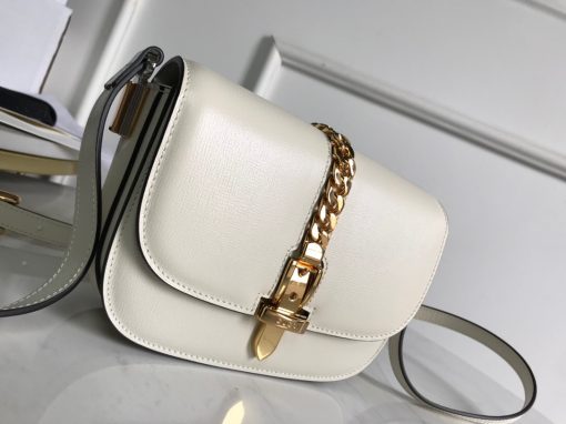 GUCCI Sylvie 1969 Mini Shoulder Bag. Original Quality Bag including gift box, care book, dust bag, authenticity card. Introduced in a mini size for Pre-Fall 2020, the Sylvie 1969 shoulder bag is designed with its original archetype in mind, unifying the details of its archival inspiration with a contemporary spirit. The shoulder bag in textured leather is defined by a narrow gold-toned metal chain fitted to the flap. The softly rounded silhouette is completed with an adjustable strap that can be worn on one shoulder or cross body.