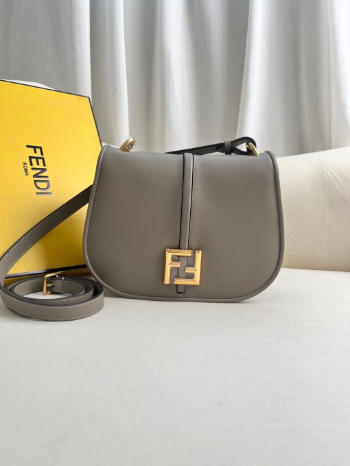 FENDI C’mon Medium. Timeless Elegance, Embodied in Leather. Elegantly designed, this medium-sized satchel bag boasts graceful, curved lines that exude femininity. Its elongated flap is adorned with a striking metal FF logo, adding a touch of sophistication to its overall charm. Crafted from supple leather with meticulously embossed edges and intricate details, this bag radiates a sense of refined luxury. The sides of the bag seamlessly blend with the overall design, crafted from the same tone-on-tone full-grain leather, ensuring a harmonious and visually pleasing aesthetic.