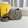 FENDI C’mon Mini. Embrace Elegance: Stefano Pilati's Curvaceous Creation. A petite satchel bag, graced with graceful, feminine curves, represents a masterpiece from the illustrious collection envisioned by the renowned Stefano Pilati. Fashioned from sumptuously smooth leather, this exquisite piece is adorned with meticulously embossed accents and edges, culminating in a striking FF logo proudly showcased on its elegant flap.