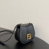 FENDI C’mon Mini. Embrace Elegance: Stefano Pilati's Curvaceous Creation. A petite satchel bag, graced with graceful, feminine curves, represents a masterpiece from the illustrious collection envisioned by the renowned Stefano Pilati. Fashioned from sumptuously smooth leather, this exquisite piece is adorned with meticulously embossed accents and edges, culminating in a striking FF logo proudly showcased on its elegant flap.
