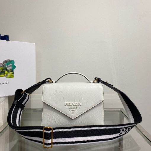 PRADA Monochrome Saffiano And Leather Bag. Original Quality Bag including gift box, care book, dust bag, authenticity card. The refined design of the Prada Monochrome bag in Saffiano leather is emphasized by the tonal effect of the iconic logo. Clean elegant lines define the bag made versatile by the removable woven tape shoulder strap embroidered with the logo in a contrasting color.