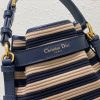 DIOR Small C'est Bag: Timeless Elegance, Effortless Style. Introducing the C'est Dior bag, a timeless and elegant creation for Fall 2023. Crafted in natural and denim blue raffia, it beautifully features the classic Marinière motif from ready-to-wear. Securing your essentials with a sophisticated CD Lock closure adorned with a twisting letter D, this bucket bag combines style with practicality. With a top handle and an adjustable, removable chain strap featuring a leather insert, this small-sized bag offers versatile carrying options—be it hand-held or comfortably draped over the shoulder.