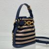DIOR Small C'est Bag: Timeless Elegance, Effortless Style. Introducing the C'est Dior bag, a timeless and elegant creation for Fall 2023. Crafted in natural and denim blue raffia, it beautifully features the classic Marinière motif from ready-to-wear. Securing your essentials with a sophisticated CD Lock closure adorned with a twisting letter D, this bucket bag combines style with practicality. With a top handle and an adjustable, removable chain strap featuring a leather insert, this small-sized bag offers versatile carrying options—be it hand-held or comfortably draped over the shoulder.