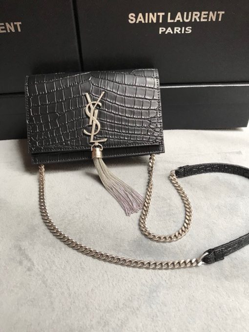 SAINT LAURENT Small 'Kate' Bag with Tassel. Original Quality Bag including gift box, care book, dust bag, authenticity card. Monogram Saint Laurent bag adorned with a curb chain, interlocking YSL initials in metal, and a metallic tassel. Crafted from leather, this Kate shoulder bag from Saint Laurent is decorated with a signature YSL monogram plaque and a hanging tassel detail to the front for an extra refined touch. The perfect go-to for a night out. Featuring a chain shoulder strap, a foldover top with magnetic closure, a main internal compartment, an internal slip pocket, an internal logo patch, an internal logo stamp, and metal hardware.