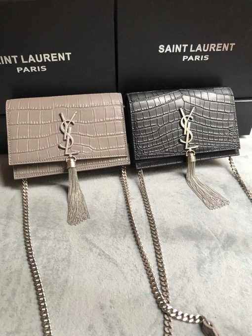 SAINT LAURENT Small 'Kate' Bag with Tassel. Original Quality Bag including gift box, care book, dust bag, authenticity card. Monogram Saint Laurent bag adorned with a curb chain, interlocking YSL initials in metal, and a metallic tassel. Crafted from leather, this Kate shoulder bag from Saint Laurent is decorated with a signature YSL monogram plaque and a hanging tassel detail to the front for an extra refined touch. The perfect go-to for a night out. Featuring a chain shoulder strap, a foldover top with magnetic closure, a main internal compartment, an internal slip pocket, an internal logo patch, an internal logo stamp, and metal hardware.