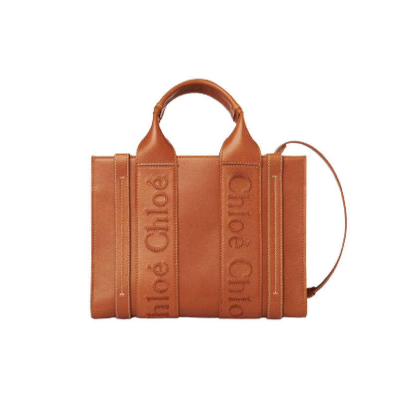 CHLOÉ Woody Tote Bag. Original Quality Bag including gift box, care book, dust bag, authenticity card. Crafted from smooth calfskin for a natural look with a unique, luxurious feel, this Woody tote bag is a soft day-to-evening bag with a long, removable strap in addition to the top handles. The roomy inside compartment includes a practical flat pocket in leather for an elevated touch. Linen lining matches a refined finish with a lower environmental impact. The Woody line is characterised by the signature Chloé logo carried over from the Maison's iconic mules. It showcases a modern, minimalist silhouette.
