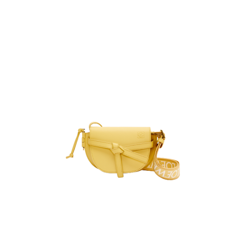 LOEWE Mini Gate Dual Bag. Discover the Art of Leather: Elevate your Style. Exquisitely designed with utmost precision, the Mini Gate Dual showcases LOEWE's unparalleled expertise in leatherwork, enveloped in supple calfskin. Its distinctive features include a meticulously saddle-stitched knotted leather strap and a side-latched metal pin, from which the bag derives its name. Moreover, this miniature rendition is equipped with a removable shoulder strap, also rendered in calfskin, embellished with a repeated LOEWE pattern crafted in jacquard.