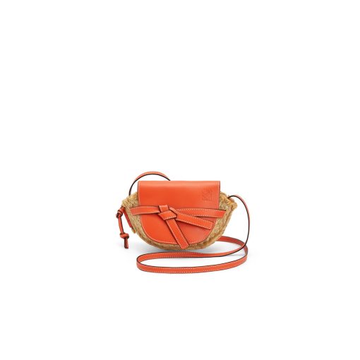 LOEWE Gate Mini Raffia Crossbody Bag. Original Quality Bag. Authentic Soft Calfskin and Woven Raffia. LOEWE Sales Box and Dust Bag. Booklet, Authenticity Card, Payment Slip. Finish off your look with this summery woven raffia iteration of Loewe's beloved Gate bag. The mini silhouette features a contrasting flap closure, which has been made from calf leather with an elegant knot detail wrapping over the front. Think of it as the sort of piece that you'll buy now but love forever.