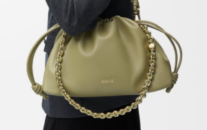 Luxury men’s bags – PRADA Brique Leather Bag and GUCCI GG Supreme Messenger displayed on a sleek marble table.