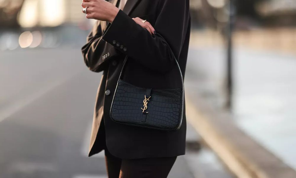 A stylish woman confidently carrying a bag.