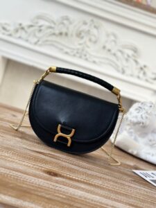 Marcie Chain Flap Bag. Authentic quality luxury bag crafted in genuine leather comes with authenticity card, dust bag and gift bag. Elevating Iconic Elegance: Marcie Line Redefined. Experience a fresh take on *loé's iconic Marcie line with this exquisite chain flap bag, meticulously crafted from a captivating blend of nappa lambskin, grained calfskin, and sumptuous suede. The line's signature hardware undergoes a graceful transformation, now adorned with *loé's engraved jewelry hallmark, adorning the flap with sophistication. An intricately hand-braided top handle pays homage to another hallmark Marcie feature, while a gracefully extended chain strap adds a refined touch. Whether you choose to drape it over your shoulder or wear it cross-body during the day, or opt to detach the strap and carry it by hand for a sophisticated evening ensemble, this flap bag is a versatile masterpiece. *loé's Marcie bag line effortlessly melds a feminine aesthetic with the free-spirited vibe of the '70s. An equestrian-inspired allure takes center stage, elevated by the allure of gleaming gold-toned hardware, resulting in a distinctly feminine yet timelessly chic look. | PURSE POP UP LIVE Marcie Chain Flap Bag. Authentic quality luxury bag crafted in genuine leather comes with authenticity card, dust bag and gift bag. Elevating Iconic Elegance: Marcie Line Redefined. Experience a fresh take on *loé's iconic Marcie line with this exquisite chain flap bag, meticulously crafted from a captivating blend of nappa lambskin, grained calfskin, and sumptuous suede. The line's signature hardware undergoes a graceful transformation, now adorned with *loé's engraved jewelry hallmark, adorning the flap with sophistication. An intricately hand-braided top handle pays homage to another hallmark Marcie feature, while a gracefully extended chain strap adds a refined touch. Whether you choose to drape it over your shoulder or wear it cross-body during the day, or opt to detach the strap and carry it by hand for a sophisticated evening ensemble, this flap bag is a versatile masterpiece. *loé's Marcie bag line effortlessly melds a feminine aesthetic with the free-spirited vibe of the '70s. An equestrian-inspired allure takes center stage, elevated by the allure of gleaming gold-toned hardware, resulting in a distinctly feminine yet timelessly chic look.