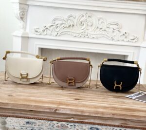 Marcie Chain Flap Bag. Authentic quality luxury bag crafted in genuine leather comes with authenticity card, dust bag and gift bag. Elevating Iconic Elegance: Marcie Line Redefined. Experience a fresh take on *loé's iconic Marcie line with this exquisite chain flap bag, meticulously crafted from a captivating blend of nappa lambskin, grained calfskin, and sumptuous suede. The line's signature hardware undergoes a graceful transformation, now adorned with *loé's engraved jewelry hallmark, adorning the flap with sophistication. An intricately hand-braided top handle pays homage to another hallmark Marcie feature, while a gracefully extended chain strap adds a refined touch. Whether you choose to drape it over your shoulder or wear it cross-body during the day, or opt to detach the strap and carry it by hand for a sophisticated evening ensemble, this flap bag is a versatile masterpiece. *loé's Marcie bag line effortlessly melds a feminine aesthetic with the free-spirited vibe of the '70s. An equestrian-inspired allure takes center stage, elevated by the allure of gleaming gold-toned hardware, resulting in a distinctly feminine yet timelessly chic look. | PURSE POP UP LIVE Marcie Chain Flap Bag. Authentic quality luxury bag crafted in genuine leather comes with authenticity card, dust bag and gift bag. Elevating Iconic Elegance: Marcie Line Redefined. Experience a fresh take on *loé's iconic Marcie line with this exquisite chain flap bag, meticulously crafted from a captivating blend of nappa lambskin, grained calfskin, and sumptuous suede. The line's signature hardware undergoes a graceful transformation, now adorned with *loé's engraved jewelry hallmark, adorning the flap with sophistication. An intricately hand-braided top handle pays homage to another hallmark Marcie feature, while a gracefully extended chain strap adds a refined touch. Whether you choose to drape it over your shoulder or wear it cross-body during the day, or opt to detach the strap and carry it by hand for a sophisticated evening ensemble, this flap bag is a versatile masterpiece. *loé's Marcie bag line effortlessly melds a feminine aesthetic with the free-spirited vibe of the '70s. An equestrian-inspired allure takes center stage, elevated by the allure of gleaming gold-toned hardware, resulting in a distinctly feminine yet timelessly chic look.