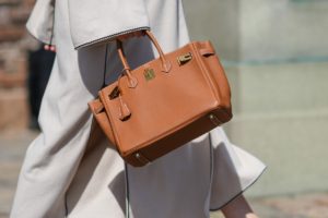 Stylish woman confidently carrying a luxury-inspired handbag