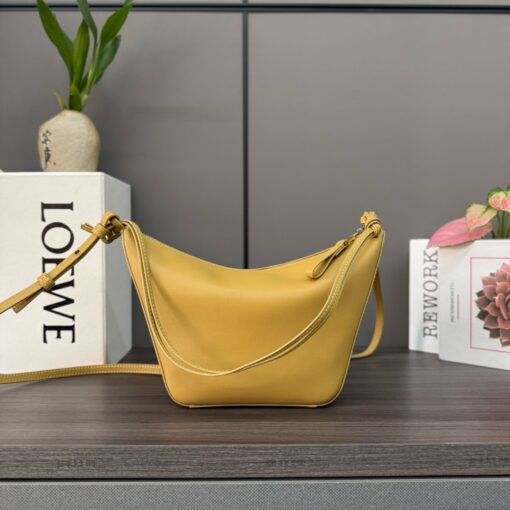 Mini Hammock Hobo. Authentic quality luxury bag crafted in genuine leather comes with authenticity card, dust bag and gift bag. Effortless Form, Everyday Function. The Mini Hammock Hobo is a contemporary reimagining of *oewe’s iconic Hammock bag. This streamlined variation offers a sleek, sculptural silhouette designed as a versatile sling bag for modern living. Expertly crafted in classic calfskin, it features soft, supple leather and a compact form that adapts effortlessly to your day. The unique design allows for multiple carry options—wear it crossbody, over the shoulder, or by hand. Elegant yet functional, this mini hobo is perfect for essentials, making it an ideal choice for both daily wear and minimalist style statements.