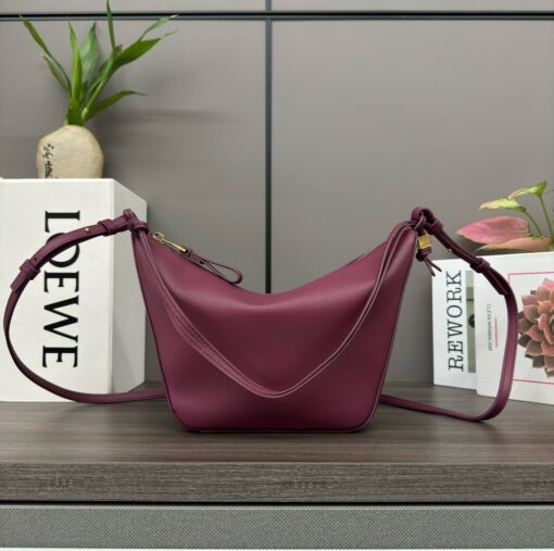 Mini Hammock Hobo. Authentic quality luxury bag crafted in genuine leather comes with authenticity card, dust bag and gift bag. Effortless Form, Everyday Function. The Mini Hammock Hobo is a contemporary reimagining of *oewe’s iconic Hammock bag. This streamlined variation offers a sleek, sculptural silhouette designed as a versatile sling bag for modern living. Expertly crafted in classic calfskin, it features soft, supple leather and a compact form that adapts effortlessly to your day. The unique design allows for multiple carry options—wear it crossbody, over the shoulder, or by hand. Elegant yet functional, this mini hobo is perfect for essentials, making it an ideal choice for both daily wear and minimalist style statements.