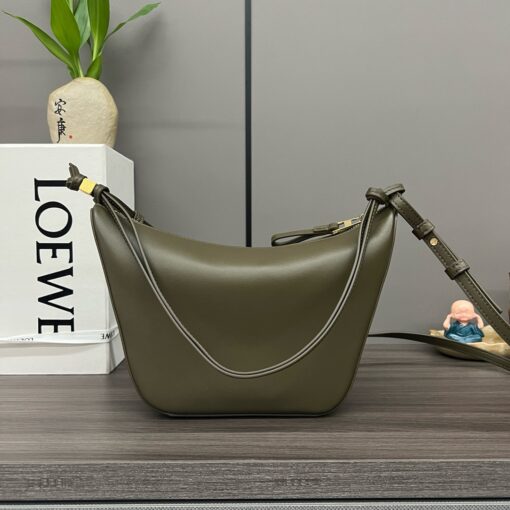 Mini Hammock Hobo. Authentic quality luxury bag crafted in genuine leather comes with authenticity card, dust bag and gift bag. Effortless Form, Everyday Function. The Mini Hammock Hobo is a contemporary reimagining of *oewe’s iconic Hammock bag. This streamlined variation offers a sleek, sculptural silhouette designed as a versatile sling bag for modern living. Expertly crafted in classic calfskin, it features soft, supple leather and a compact form that adapts effortlessly to your day. The unique design allows for multiple carry options—wear it crossbody, over the shoulder, or by hand. Elegant yet functional, this mini hobo is perfect for essentials, making it an ideal choice for both daily wear and minimalist style statements.