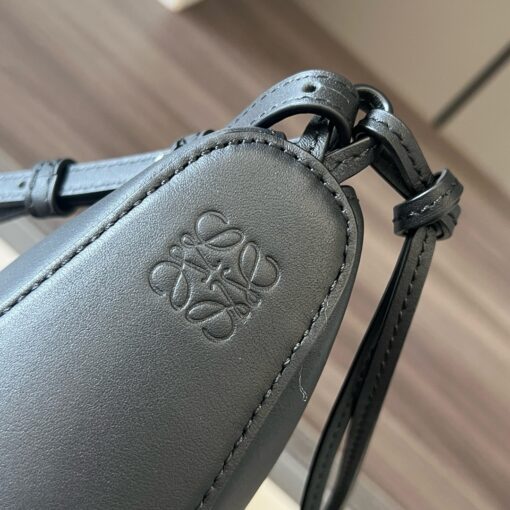 Mini Hammock Hobo. Authentic quality luxury bag crafted in genuine leather comes with authenticity card, dust bag and gift bag. Effortless Form, Everyday Function. The Mini Hammock Hobo is a contemporary reimagining of *oewe’s iconic Hammock bag. This streamlined variation offers a sleek, sculptural silhouette designed as a versatile sling bag for modern living. Expertly crafted in classic calfskin, it features soft, supple leather and a compact form that adapts effortlessly to your day. The unique design allows for multiple carry options—wear it crossbody, over the shoulder, or by hand. Elegant yet functional, this mini hobo is perfect for essentials, making it an ideal choice for both daily wear and minimalist style statements.