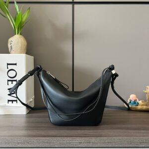 Mini Hammock Hobo. Authentic quality luxury bag crafted in genuine leather comes with authenticity card, dust bag and gift bag. Effortless Form, Everyday Function. The Mini Hammock Hobo is a contemporary reimagining of *oewe’s iconic Hammock bag. This streamlined variation offers a sleek, sculptural silhouette designed as a versatile sling bag for modern living. Expertly crafted in classic calfskin, it features soft, supple leather and a compact form that adapts effortlessly to your day. The unique design allows for multiple carry options—wear it crossbody, over the shoulder, or by hand. Elegant yet functional, this mini hobo is perfect for essentials, making it an ideal choice for both daily wear and minimalist style statements.