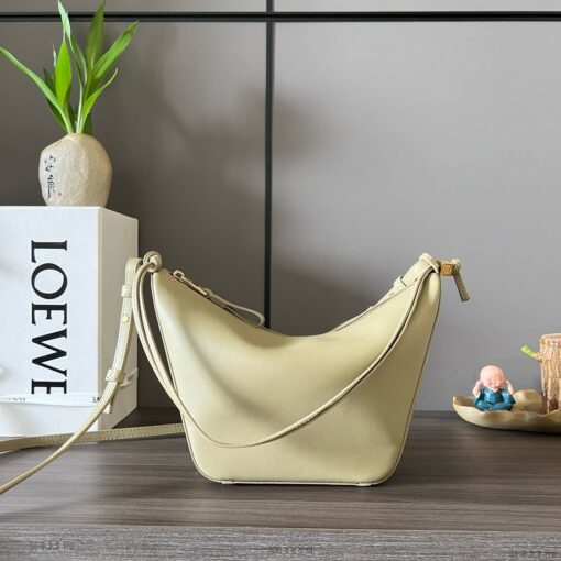 Mini Hammock Hobo. Authentic quality luxury bag crafted in genuine leather comes with authenticity card, dust bag and gift bag. Effortless Form, Everyday Function. The Mini Hammock Hobo is a contemporary reimagining of *oewe’s iconic Hammock bag. This streamlined variation offers a sleek, sculptural silhouette designed as a versatile sling bag for modern living. Expertly crafted in classic calfskin, it features soft, supple leather and a compact form that adapts effortlessly to your day. The unique design allows for multiple carry options—wear it crossbody, over the shoulder, or by hand. Elegant yet functional, this mini hobo is perfect for essentials, making it an ideal choice for both daily wear and minimalist style statements.