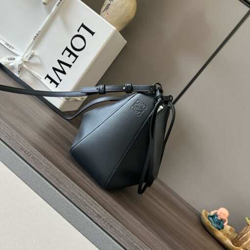 Mini Hammock Hobo. Authentic quality luxury bag crafted in genuine leather comes with authenticity card, dust bag and gift bag. Effortless Form, Everyday Function. The Mini Hammock Hobo is a contemporary reimagining of *oewe’s iconic Hammock bag. This streamlined variation offers a sleek, sculptural silhouette designed as a versatile sling bag for modern living. Expertly crafted in classic calfskin, it features soft, supple leather and a compact form that adapts effortlessly to your day. The unique design allows for multiple carry options—wear it crossbody, over the shoulder, or by hand. Elegant yet functional, this mini hobo is perfect for essentials, making it an ideal choice for both daily wear and minimalist style statements.