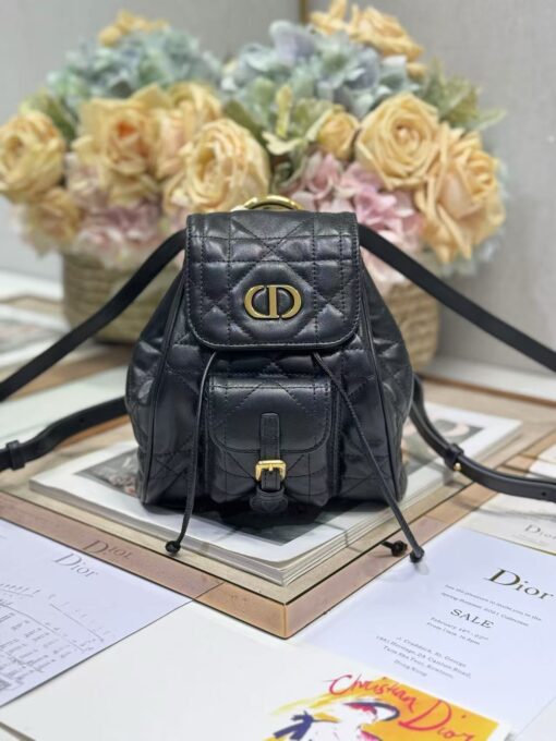 Small Caro Backpack. Authentic quality luxury bag crafted in genuine leather comes with authenticity card, dust bag and gift bag. Elegance Meets Effortless Edge. Elevate your everyday with the Small Caro Backpack — a flawless blend of modern femininity and iconic House craftsmanship. Luxuriously crafted in lambskin, its supple silhouette is enhanced by bold Macrocannage topstitching that whispers timeless *ior style. The antique gold-finish ‘CD’ clasp opens to a drawstring main compartment, perfectly balancing beauty and practicality. A discreet flap pocket keeps your daily essentials close at hand, while the top handle and adjustable leather straps offer versatile, all-day comfort. Whether slung over your shoulder or carried by hand, this petite powerhouse delivers Parisian polish in every step.