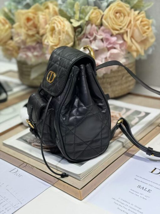 Small Caro Backpack. Authentic quality luxury bag crafted in genuine leather comes with authenticity card, dust bag and gift bag. Elegance Meets Effortless Edge. Elevate your everyday with the Small Caro Backpack — a flawless blend of modern femininity and iconic House craftsmanship. Luxuriously crafted in lambskin, its supple silhouette is enhanced by bold Macrocannage topstitching that whispers timeless *ior style. The antique gold-finish ‘CD’ clasp opens to a drawstring main compartment, perfectly balancing beauty and practicality. A discreet flap pocket keeps your daily essentials close at hand, while the top handle and adjustable leather straps offer versatile, all-day comfort. Whether slung over your shoulder or carried by hand, this petite powerhouse delivers Parisian polish in every step.