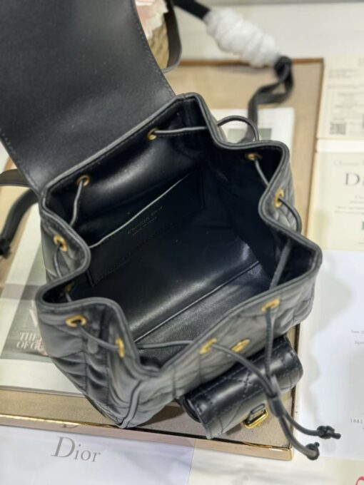 Small Caro Backpack. Authentic quality luxury bag crafted in genuine leather comes with authenticity card, dust bag and gift bag. Elegance Meets Effortless Edge. Elevate your everyday with the Small Caro Backpack — a flawless blend of modern femininity and iconic House craftsmanship. Luxuriously crafted in lambskin, its supple silhouette is enhanced by bold Macrocannage topstitching that whispers timeless *ior style. The antique gold-finish ‘CD’ clasp opens to a drawstring main compartment, perfectly balancing beauty and practicality. A discreet flap pocket keeps your daily essentials close at hand, while the top handle and adjustable leather straps offer versatile, all-day comfort. Whether slung over your shoulder or carried by hand, this petite powerhouse delivers Parisian polish in every step.