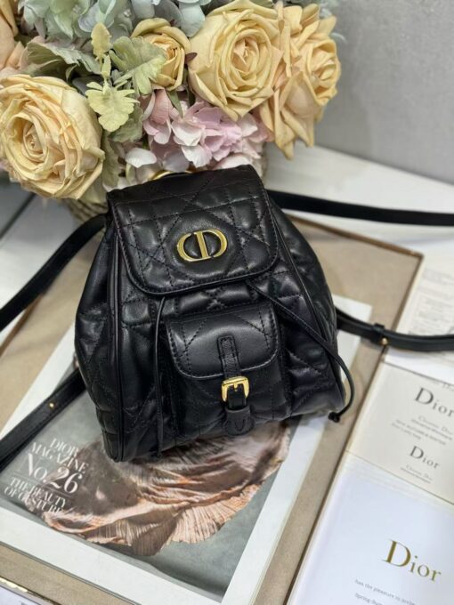 Small Caro Backpack. Authentic quality luxury bag crafted in genuine leather comes with authenticity card, dust bag and gift bag. Elegance Meets Effortless Edge. Elevate your everyday with the Small Caro Backpack — a flawless blend of modern femininity and iconic House craftsmanship. Luxuriously crafted in lambskin, its supple silhouette is enhanced by bold Macrocannage topstitching that whispers timeless *ior style. The antique gold-finish ‘CD’ clasp opens to a drawstring main compartment, perfectly balancing beauty and practicality. A discreet flap pocket keeps your daily essentials close at hand, while the top handle and adjustable leather straps offer versatile, all-day comfort. Whether slung over your shoulder or carried by hand, this petite powerhouse delivers Parisian polish in every step.