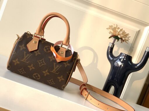 Speedy Nano. Authentic quality luxury bag crafted in genuine leather comes with authenticity card, dust bag and gift bag. Iconic Style, Perfectly Miniaturized. Meet the LV Speedy Nano — a petite powerhouse that captures the timeless allure of the iconic Speedy in its most charming form. Revamped in classic Monogram canvas and finished with aged natural cowhide leather, this mini marvel is made for the modern minimalist. Crafted with delicate gold-tone hardware and featuring two signature top handles, the Speedy Nano is both playful and practical. Its removable, adjustable shoulder strap adds effortless versatility—carry it by hand for polished poise or sling it crossbody for chic, on-the-go ease. Compact enough for your essentials. Iconic enough to turn heads. Small bag, big legacy!