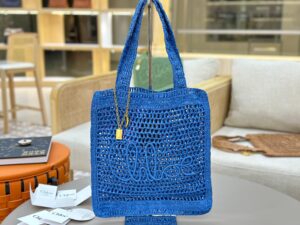 Summer Banana Tote Bag. Authentic quality luxury bag crafted in genuine leather comes with authenticity card, dust bag and gift bag. Heritage in Hand: Where Artisan Craft Meets Summer Elegance. Introducing the Summer Banana Tote—an artisanal masterpiece crafted from raffia and calfskin by a single artisan over 4.5 days in partnership with Made For A Woman. This spacious tote is adorned with a handwritten signature inspired by *loé’s rich heritage, while a playful dangling chain and delicate charms add the perfect finishing touch. A celebration of craftsmanship and effortless summer style.