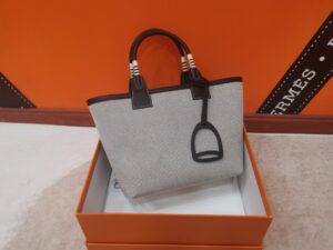 Steeple 25 Bag. Authentic quality luxury bag crafted in genuine leather comes with authenticity card, dust bag and gift bag. Where art meets heritage. The *rmès Steeple Bag is a charming fusion of heritage and artistry, crafted from a blend of canvas and Swift leather. Its design pays tribute to *rmès’ equestrian roots with whip-shaped handles and a stirrup-inspired charm, adding a playful yet sophisticated touch. Lightweight yet spacious, the Steeple is ideal for daily use. Whether you opt for a vibrant motif or a sleek, single-color design, this bag stands out as an artistic expression of luxury that seamlessly integrates into a modern lifestyle. Praised for its unique aesthetic and accessibility within the *rmès lineup, the Steeple Bag is adored by fashion enthusiasts who appreciate its colorful palette and bold personality. While it’s best suited for those who enjoy the texture and look of canvas, it remains a versatile statement piece that captures the spirit of everyday elegance. | PURSE POP UP LIVE Steeple 25 Bag. Authentic quality luxury bag crafted in genuine leather comes with authenticity card, dust bag and gift bag. Where art meets heritage. The *rmès Steeple Bag is a charming fusion of heritage and artistry, crafted from a blend of canvas and Swift leather. Its design pays tribute to *rmès’ equestrian roots with whip-shaped handles and a stirrup-inspired charm, adding a playful yet sophisticated touch. Lightweight yet spacious, the Steeple is ideal for daily use. Whether you opt for a vibrant motif or a sleek, single-color design, this bag stands out as an artistic expression of luxury that seamlessly integrates into a modern lifestyle. Praised for its unique aesthetic and accessibility within the *rmès lineup, the Steeple Bag is adored by fashion enthusiasts who appreciate its colorful palette and bold personality. While it’s best suited for those who enjoy the texture and look of canvas, it remains a versatile statement piece that captures the spirit of everyday elegance.