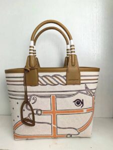 Steeple 25 Bag. Authentic quality luxury bag crafted in genuine leather comes with authenticity card, dust bag and gift bag. Where art meets heritage. The *rmès Steeple Bag is a charming fusion of heritage and artistry, crafted from a blend of canvas and Swift leather. Its design pays tribute to *rmès’ equestrian roots with whip-shaped handles and a stirrup-inspired charm, adding a playful yet sophisticated touch. Lightweight yet spacious, the Steeple is ideal for daily use. Whether you opt for a vibrant motif or a sleek, single-color design, this bag stands out as an artistic expression of luxury that seamlessly integrates into a modern lifestyle. Praised for its unique aesthetic and accessibility within the *rmès lineup, the Steeple Bag is adored by fashion enthusiasts who appreciate its colorful palette and bold personality. While it’s best suited for those who enjoy the texture and look of canvas, it remains a versatile statement piece that captures the spirit of everyday elegance. | PURSE POP UP LIVE Steeple 25 Bag. Authentic quality luxury bag crafted in genuine leather comes with authenticity card, dust bag and gift bag. Where art meets heritage. The *rmès Steeple Bag is a charming fusion of heritage and artistry, crafted from a blend of canvas and Swift leather. Its design pays tribute to *rmès’ equestrian roots with whip-shaped handles and a stirrup-inspired charm, adding a playful yet sophisticated touch. Lightweight yet spacious, the Steeple is ideal for daily use. Whether you opt for a vibrant motif or a sleek, single-color design, this bag stands out as an artistic expression of luxury that seamlessly integrates into a modern lifestyle. Praised for its unique aesthetic and accessibility within the *rmès lineup, the Steeple Bag is adored by fashion enthusiasts who appreciate its colorful palette and bold personality. While it’s best suited for those who enjoy the texture and look of canvas, it remains a versatile statement piece that captures the spirit of everyday elegance.