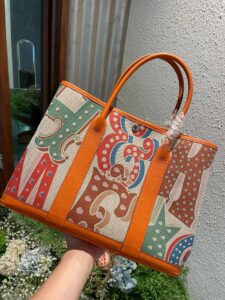Garden Party Voyage. Authentic quality luxury bag crafted in genuine leather comes with authenticity card, dust bag and gift bag. The Art of Everyday Escape. Chic, structured, and effortlessly refined, the *RMÈS Garden Party Voyage is the perfect companion for your daily adventures or spontaneous weekend getaways. Crafted with precision in supple Negonda leather or canvas with leather trim, this midsize tote strikes the perfect balance between luxury and functionality. Its minimalist silhouette is elevated by discreet Clou de Selle snap closures and expandable sides, offering both form and flexibility. Spacious enough for your essentials yet compact enough to carry with ease, it’s a timeless piece designed to move with you—gracefully. Whether carried in hand or worn over the shoulder, the Garden Party Voyage 36 speaks in whispers of elegance and unmistakable *RMÈS craftsmanship. Every day is a journey. Travel beautifully. | PURSE POP UP LIVE Garden Party Voyage. Authentic quality luxury bag crafted in genuine leather comes with authenticity card, dust bag and gift bag. The Art of Everyday Escape. Chic, structured, and effortlessly refined, the *RMÈS Garden Party Voyage is the perfect companion for your daily adventures or spontaneous weekend getaways. Crafted with precision in supple Negonda leather or canvas with leather trim, this midsize tote strikes the perfect balance between luxury and functionality. Its minimalist silhouette is elevated by discreet Clou de Selle snap closures and expandable sides, offering both form and flexibility. Spacious enough for your essentials yet compact enough to carry with ease, it’s a timeless piece designed to move with you—gracefully. Whether carried in hand or worn over the shoulder, the Garden Party Voyage 36 speaks in whispers of elegance and unmistakable *RMÈS craftsmanship. Every day is a journey. Travel beautifully.